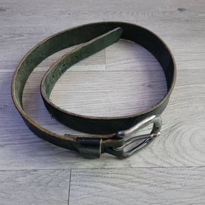 Black mottled leather belt with a silver buckle and a green suede underside